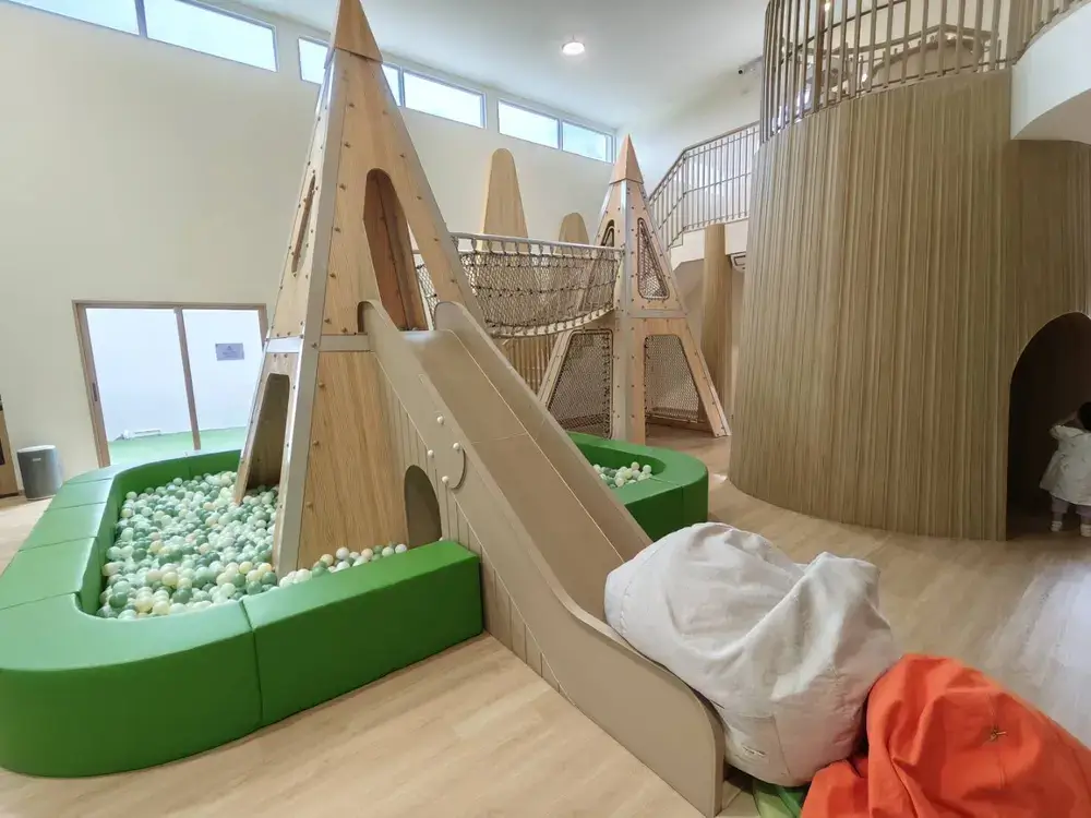 ツリーハウスをイメージした室内の大型木製遊具と滑り台