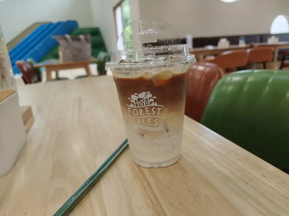 カフェのテーブル席で楽しむアイスカフェラテ